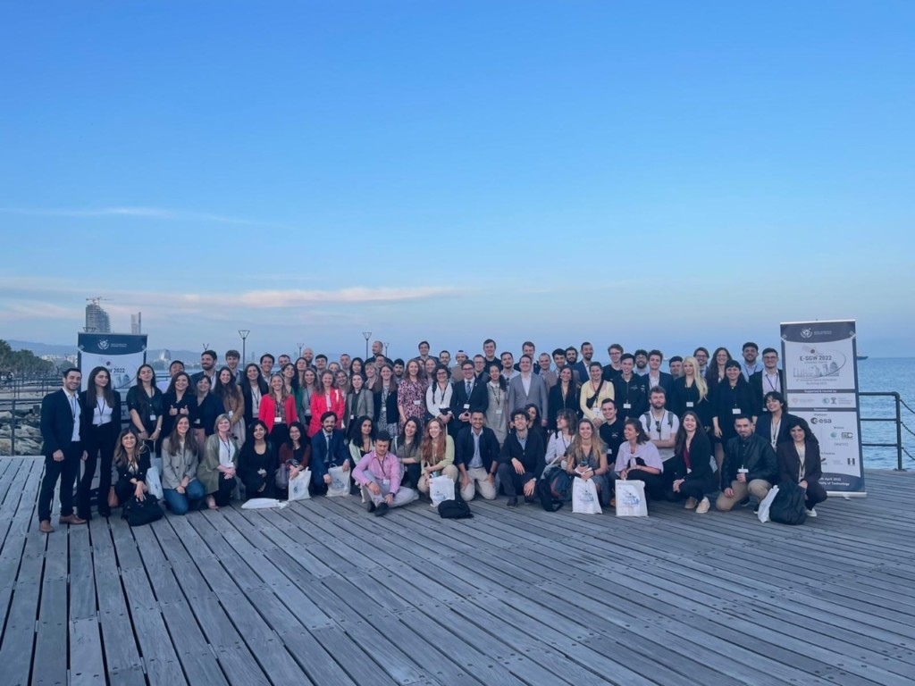 A photo of the participants of the E-SGW 2022 in Limassol, Cyprus. There are three rows of young people and the SGAC banner to one side.
